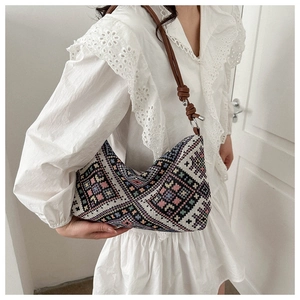 Close-up of bohemian hobo bag featuring colorful geometric patterns and knotted brown strap