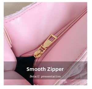 Macro shot of the smooth gold metal zipper detail on this pink fashion puffer tote bag