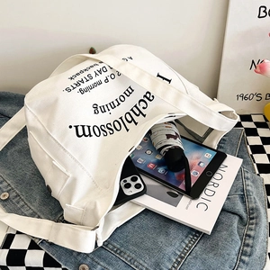 Large white canvas tote bag with lettering showing internal storage for iPad and umbrella