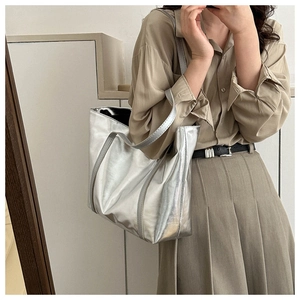 Silver metallic tote bag shown on model shoulder for commuter fashion style
