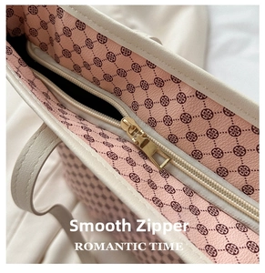 Close-up of smooth gold zipper and pink monogram lining of the stylish tote bag
