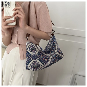 Detailed close-up of bohemian jacquard canvas tote with ethnic floral patterns and leather strap