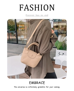 Beige PU leather bucket bag worn by model in a casual outdoor cafe setting