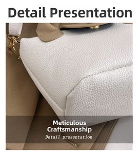 Close-up of contrast stitching on white and khaki lychee grain leather bucket bag