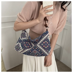 Detailed view of bohemian geometric pattern knit bag with thick rope knotted shoulder strap