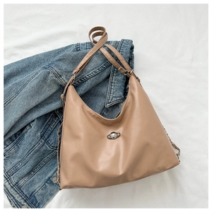 Detailed shot of the light brown faux leather bag with silver planet metal hardware
