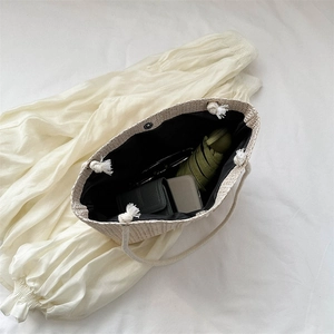 Beige woven straw tote bag with cotton rope handles and large interior storage space