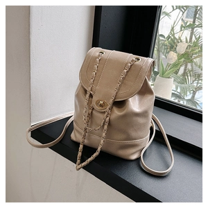 Detail of a khaki mini chain backpack in glossy oil wax leather with a metal turn-lock