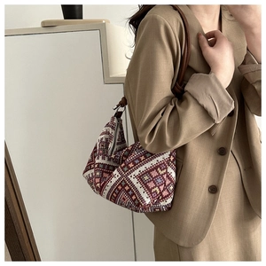 Close-up of bohemian jacquard woven handbag with leather strap and metal zipper