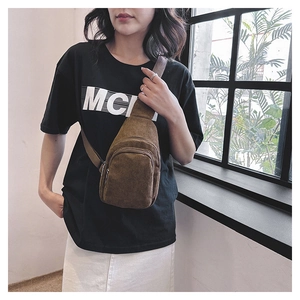 Detail of brown corduroy waist bag showing soft vertical ribbed texture and zippers