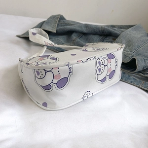 Cute white shoulder bag with purple cartoon dog print and matching strap over denim jacket