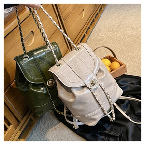 Detail of mini chain backpack with glossy oil-wax leather texture and metal twist lock