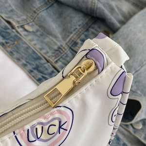 White casual single shoulder bag with LUCK print and gold zipper on denim background