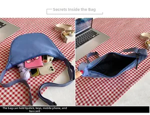Spacious interior of blue nylon crescent bag showing phone, umbrella and cosmetics