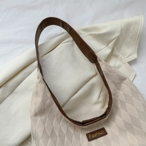Minimalist beige quilted tote bag with brown faux leather straps and fashion label