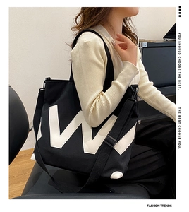 Détail du cabas en toile avec logo W blanc et bandoulière réglable pour femmes