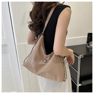 Detail of premium beige PU leather tote with unique planet buckle and metal chain strap