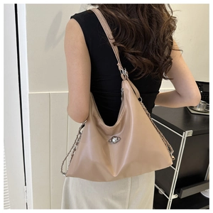 Close-up of khaki shoulder bag with metallic planet logo and chain strap detail