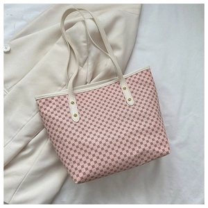 Top view of pink geometric pattern tote bag with cream leather trim and gold rivets