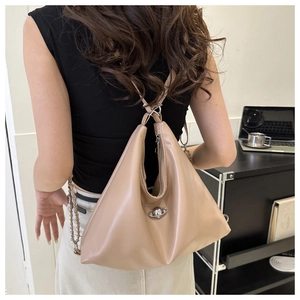 Detail of beige leather multi-functional backpack with unique triangular shape and metal ball