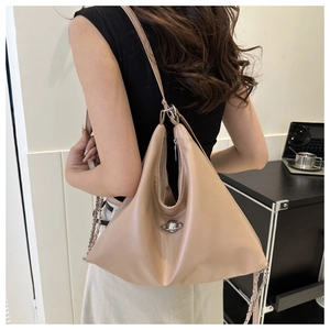 Detail of apricot Hobo bag showing the silver planet metal logo and chain strap