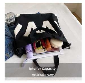 Vue de dessus d'un grand sac cabas en toile noire montrant l'intérieur spacieux et objets