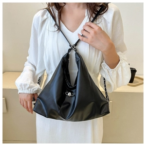 Detail of black pleated faux leather crossbody bag with silver planet logo and shoulder strap