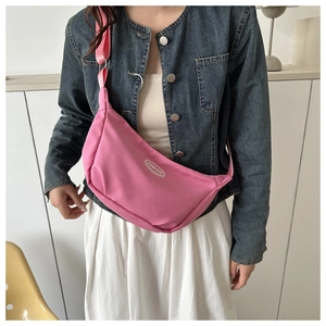Detail showing pink nylon crescent bag with adjustable strap and Fashion logo patch