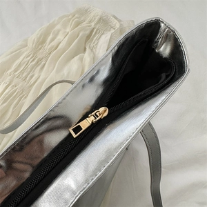 Metallic silver tote bag featuring high-end brushed texture and gold zipper closure