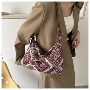 Close-up of ethnic geometric woven crossbody bag with detailed knotted leather strap