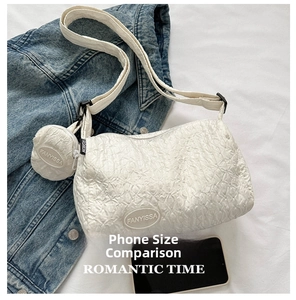 Detail of white quilted nylon dumpling bag with matching mini round coin purse charm