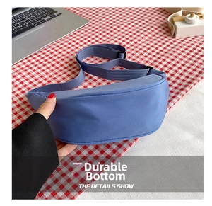 Detail shot of a light blue nylon crossbody bag with durable bottom and adjustable strap