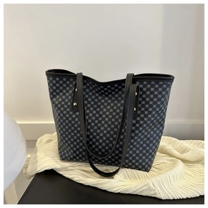 Detail of navy blue tote bag featuring geometric dot pattern and sturdy black handles