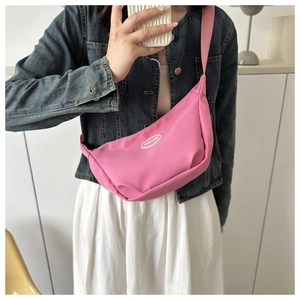 Pink canvas half-moon bag worn as a crossbody with white Fashion logo patch