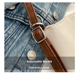 Detail of adjustable brown leather shoulder strap with a silver metal buckle closure