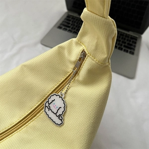 Pale yellow fabric crossbody bag with silver zipper and cute white dog pendant charm