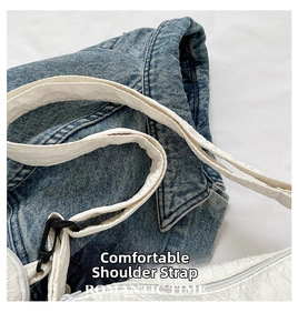 Detail of white wrinkled fabric shoulder bag with wide strap and black buckle