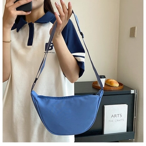 Close-up of blue nylon crescent bag with adjustable strap and waterproof texture