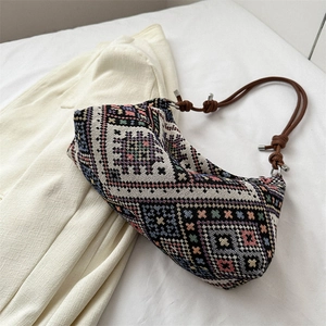 Bohemian style woven crescent bag with geometric patterns and brown cord strap