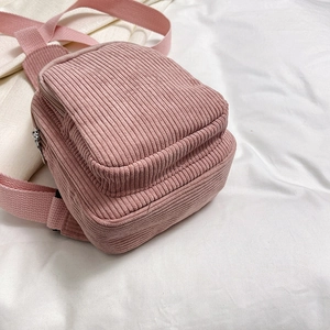 Pink corduroy crossbody bag for women with minimalist design on soft white fabric background