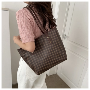 Detail showing vintage pattern tote bag with gold rivet accents and long brown straps