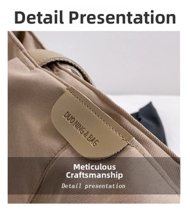 Detail of khaki canvas tote with Duo Ning & Bag leather patch and precision stitching