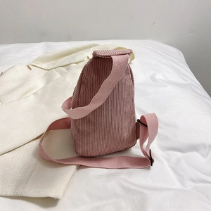 Pink corduroy crossbody fanny pack for women shown against a clean white suit jacket