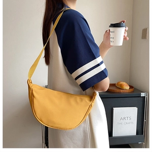 Detailed view of a bright yellow nylon crescent crossbody bag with adjustable strap