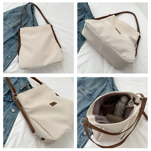 Close-up of large canvas tote bag showing brown leather patch and spacious interior