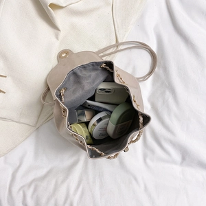 Mini cream drawstring bucket backpack with chain detail showing large storage capacity