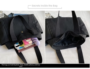 Detail view of large black canvas tote bag interior with zipper pocket and wide straps
