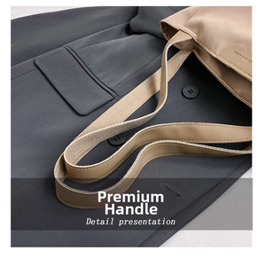 Detail showing high-quality khaki fabric handles with leather accents on a tote bag