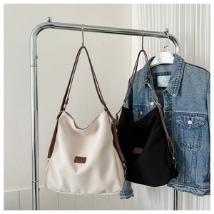 Detail of minimalist Hobo shoulder bags with slim leather straps and vintage logo patch
