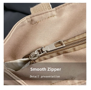 Detail shot of a smooth silver metal zipper on a khaki canvas tote bag for women